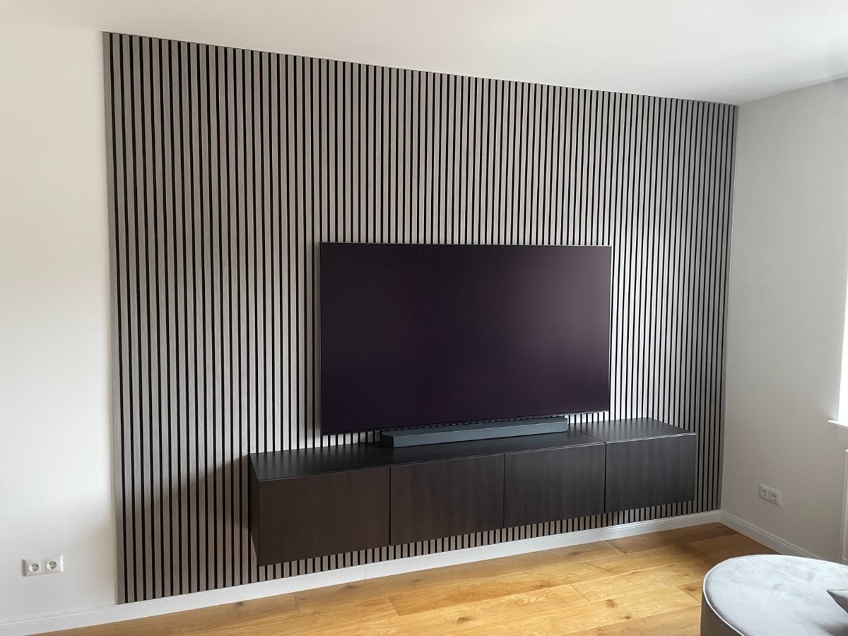 Wohnzimmer mit montierter Holzlamellenwand und TV-Lowboard – Referenz Montageservice Neufeld